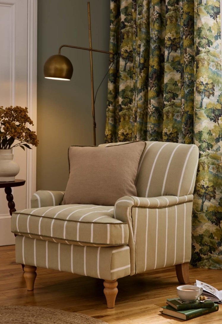 Upholstered striped armchair in a living room, finished with a contrast piped cushion
