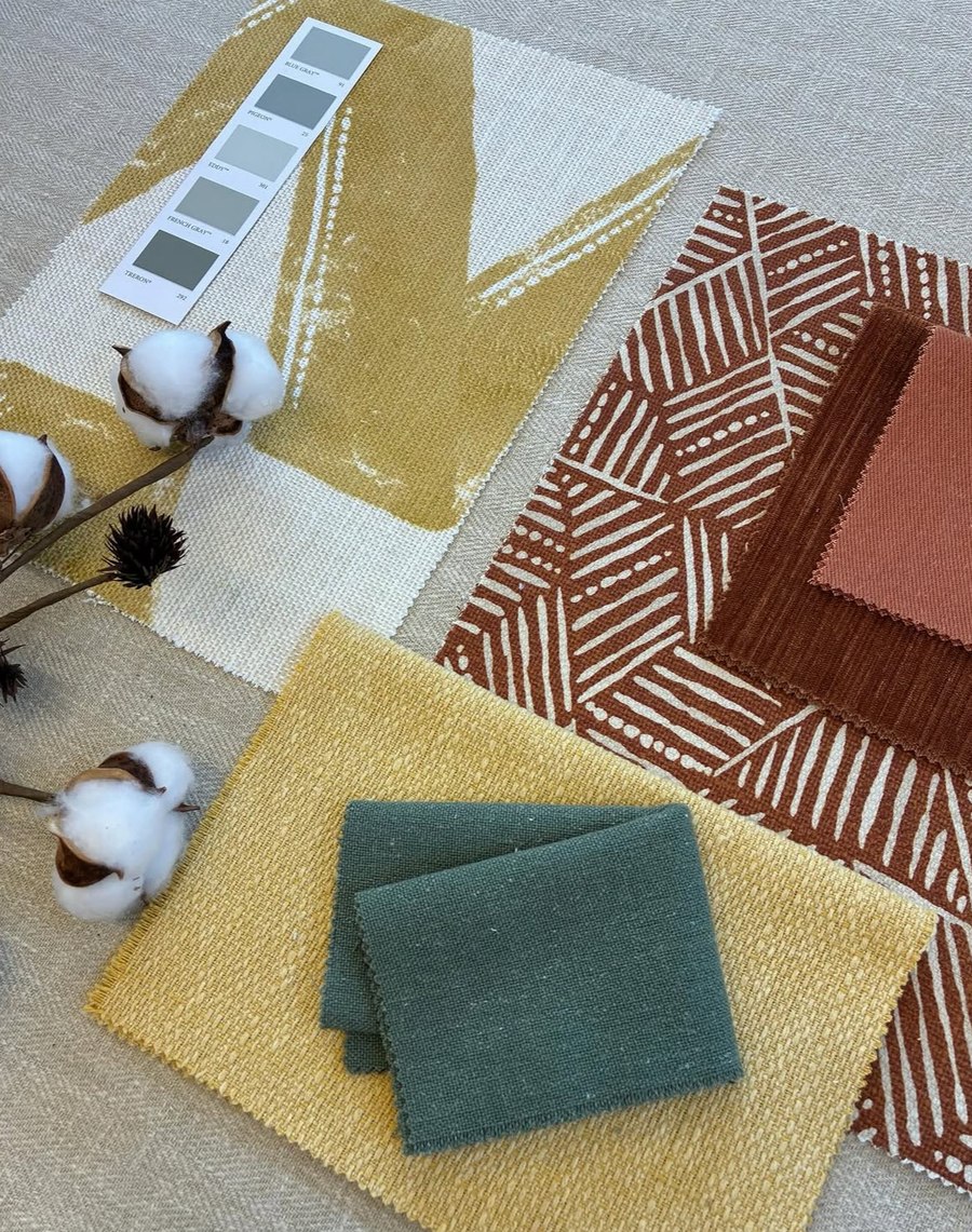Fabric swatches and colour cards laid out for a bespoke scheme