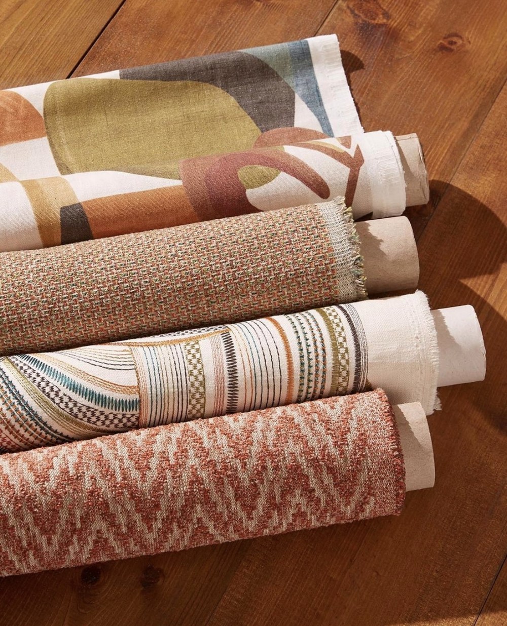 A range of fabric rolls, from natural weaves to patterned textiles